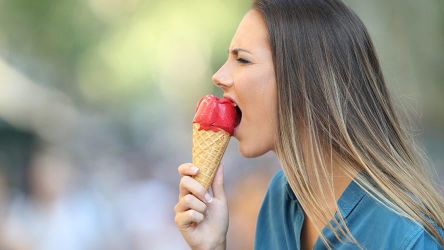 kobieta z nadwrażliwymi zębami jedząca lody
