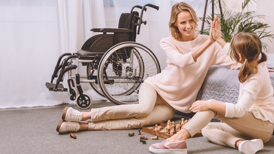 matka i córka grające w szachy w tle wózek inwalidzki
