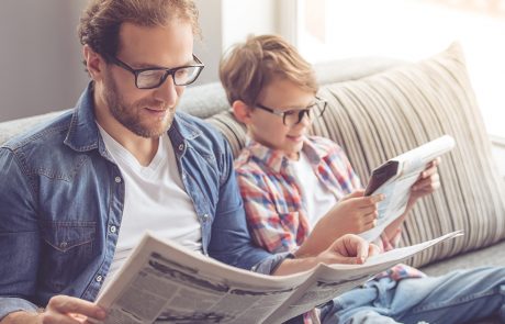 ojciec i syn w okularach czytający gazety