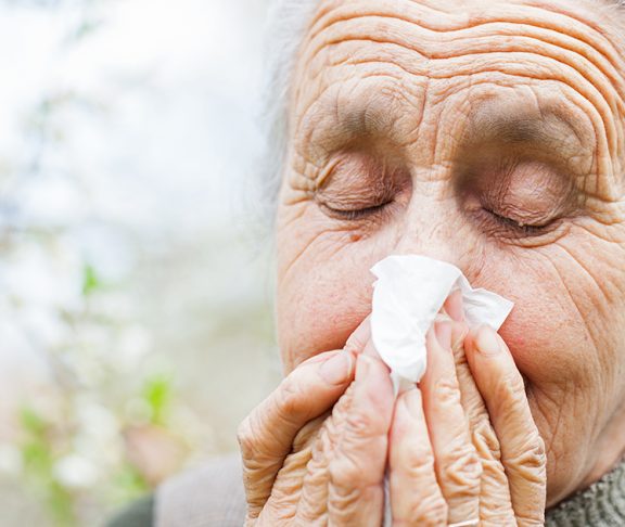 starsza kobieta wydmuchująca nos