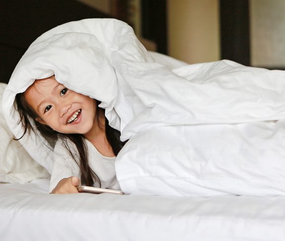 Smiling child under the covers
