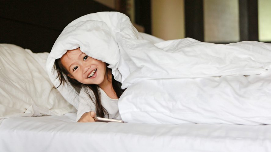 Smiling child under the covers