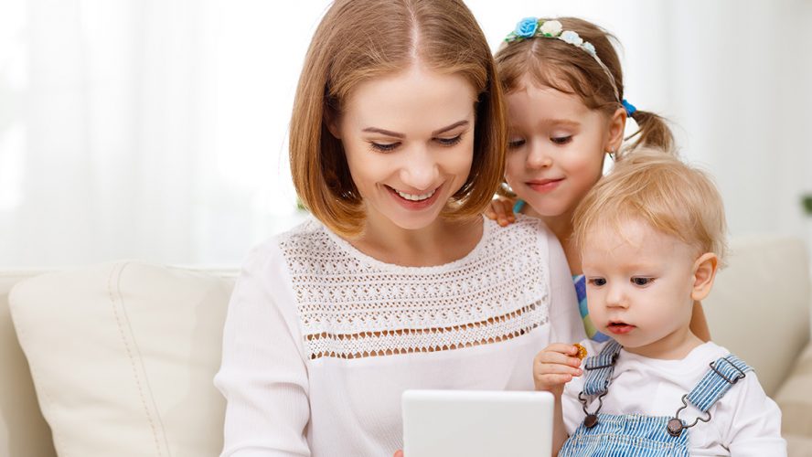 Mom and two babies looking at a tablet