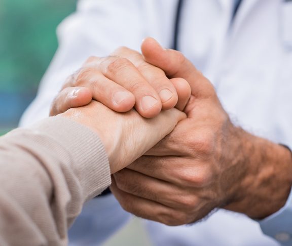 A doctor holding a patient's hand