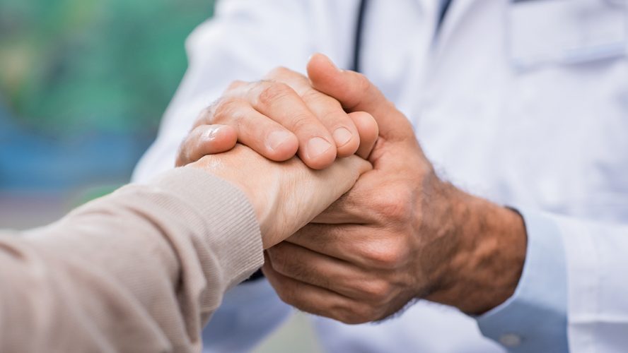 A doctor holding a patient's hand