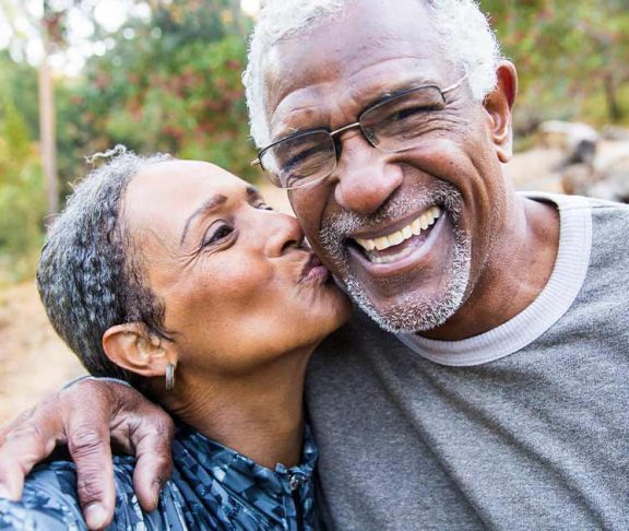 Black senior couple smiling for a kissing selfie
