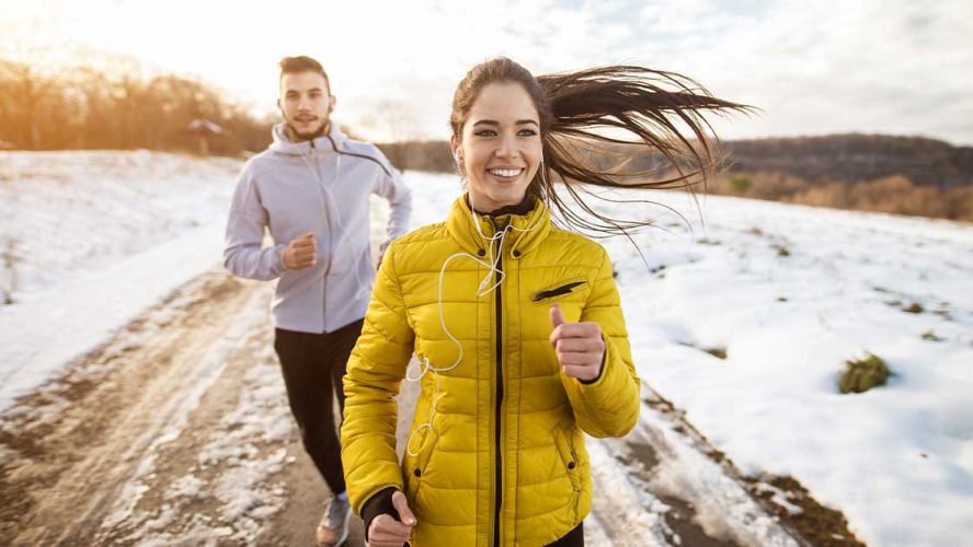 Two people happy to be running outside in the winter