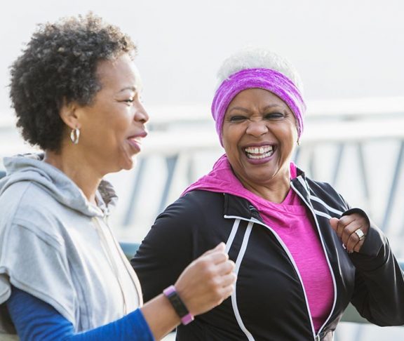 Two senior Black women running outdoors