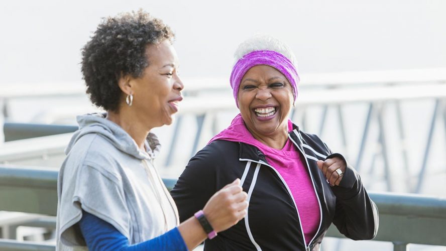 Two senior Black women running outdoors