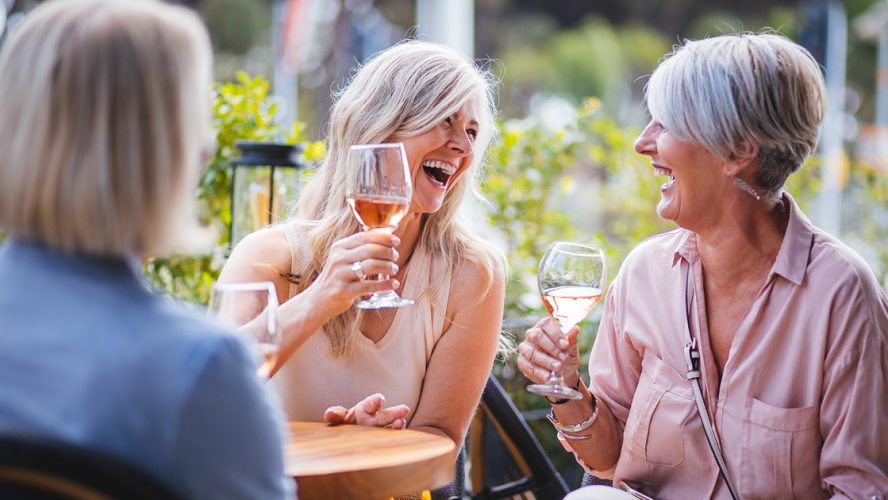 Senior women drinking wine and laughing