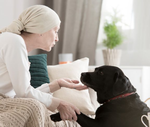 Woman with cancer patting dog
