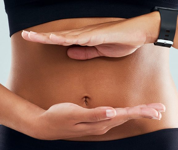 Woman framing her stomach with her hands