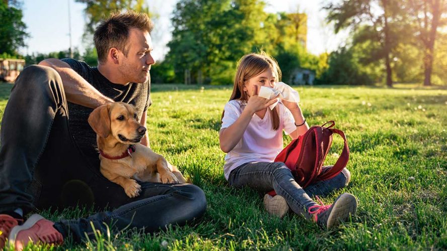 Girl in park with allergies, her dad, and their dog
