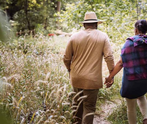Older couple walking through a field