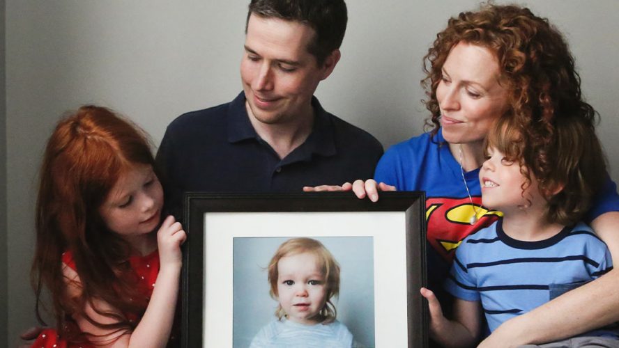 The Promoli family with a framed photograph of Jude