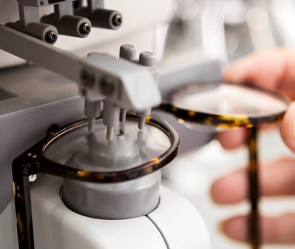 Opthamologist using equipment to work on eyeglass lenses