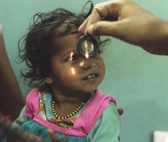 Young Nepalese girl getting her eyes checked by optometrist