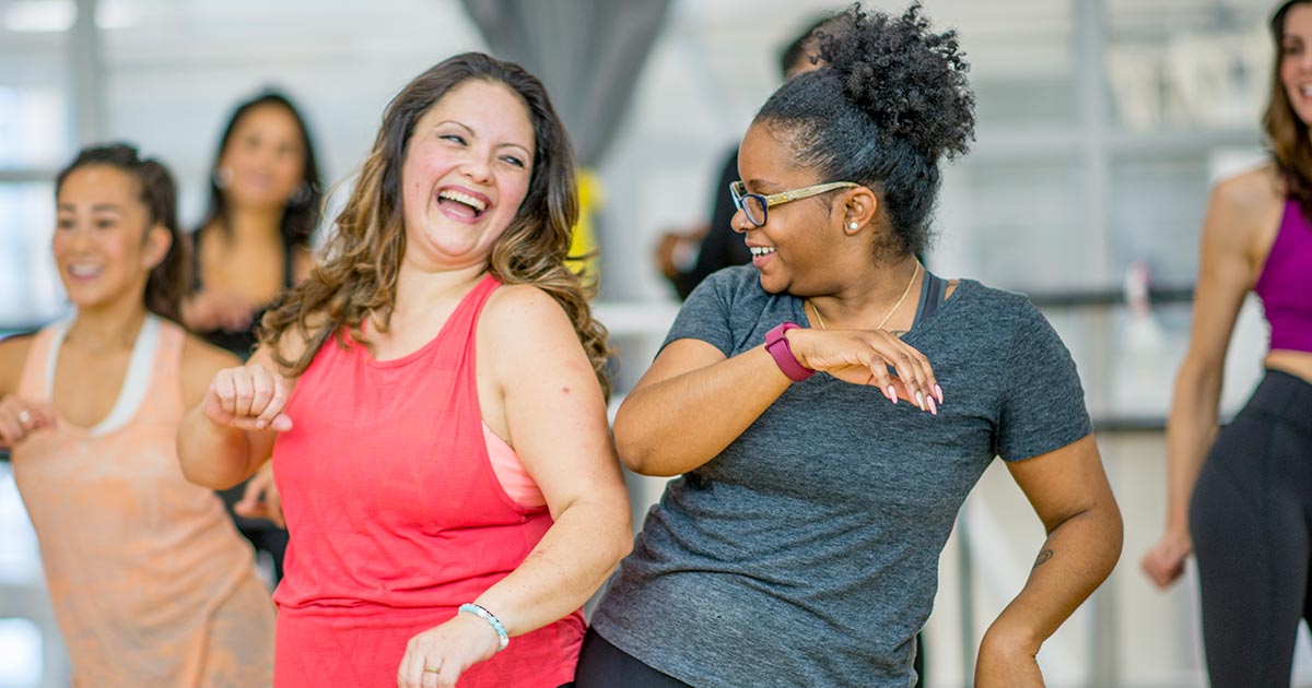 Two women dancing together at a fitness class