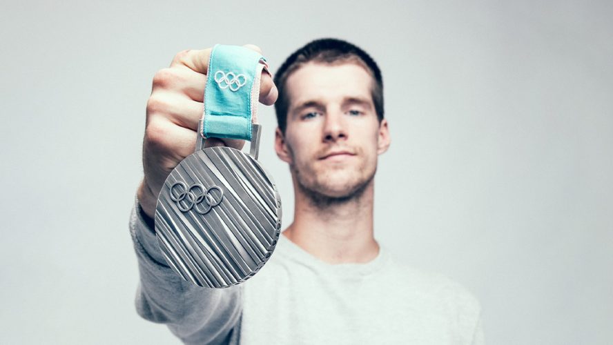 Max Parrot holding up his Olympic medal