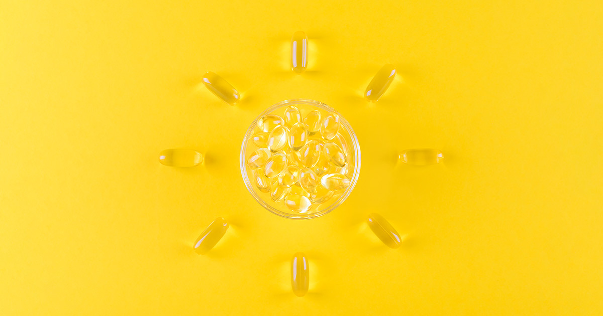 Vitamin D capsules on a yellow background