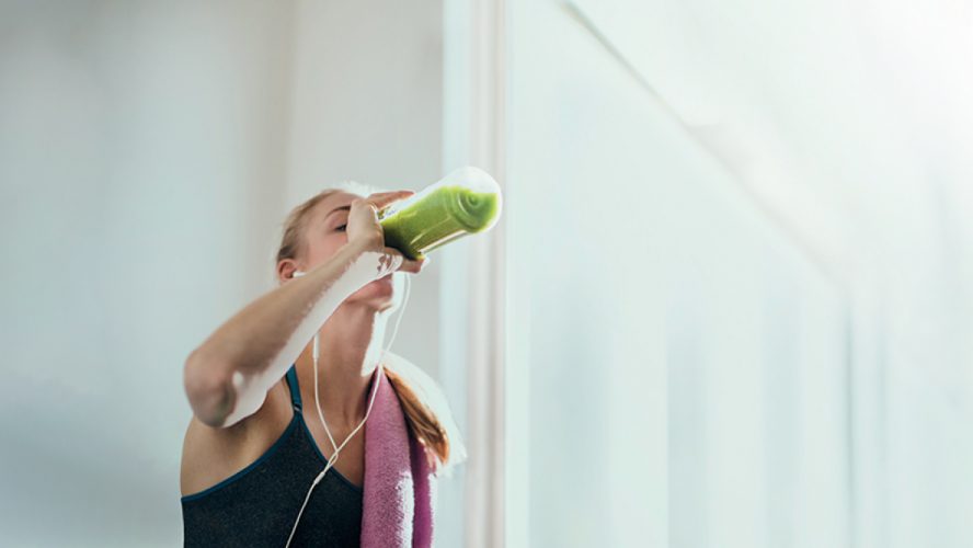 Woman drinking from a water bottle while working out