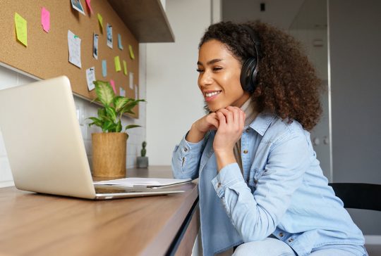 Woman-Listening-To-Headphones-On-Laptop