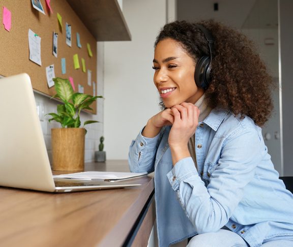 Woman-Listening-To-Headphones-On-Laptop