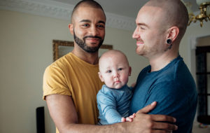 two men holding baby