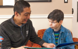 man reading book to disabled child