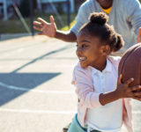 young african american girl playing basketball