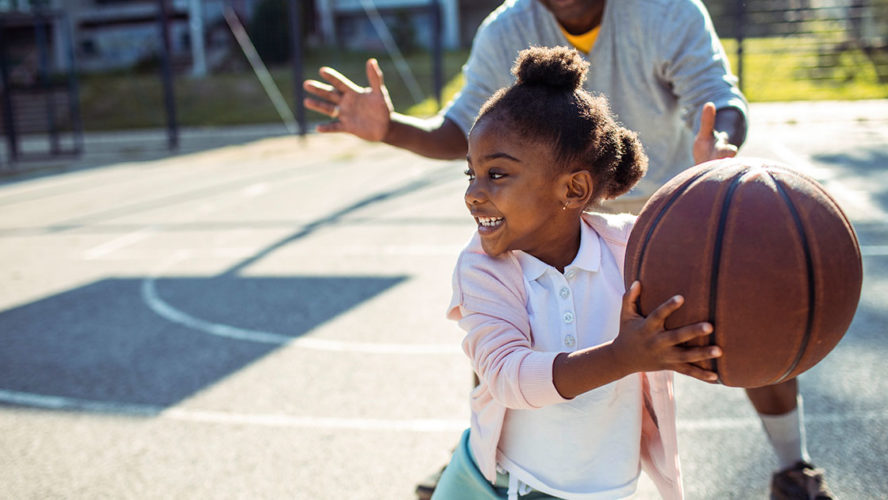 young african american girl playing basketball