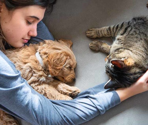 young woman laying beside pets