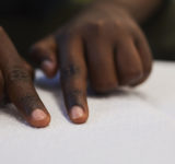 A close up of a child reading braille