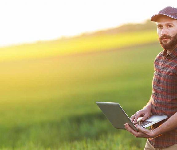 Farmer using laptop in a field