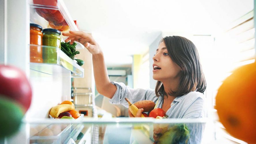 Woman choosing fresh food from her fridge