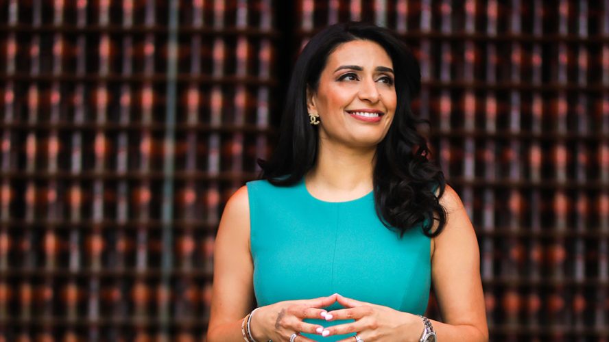 Manjit Minhas smiling and looking off-camera