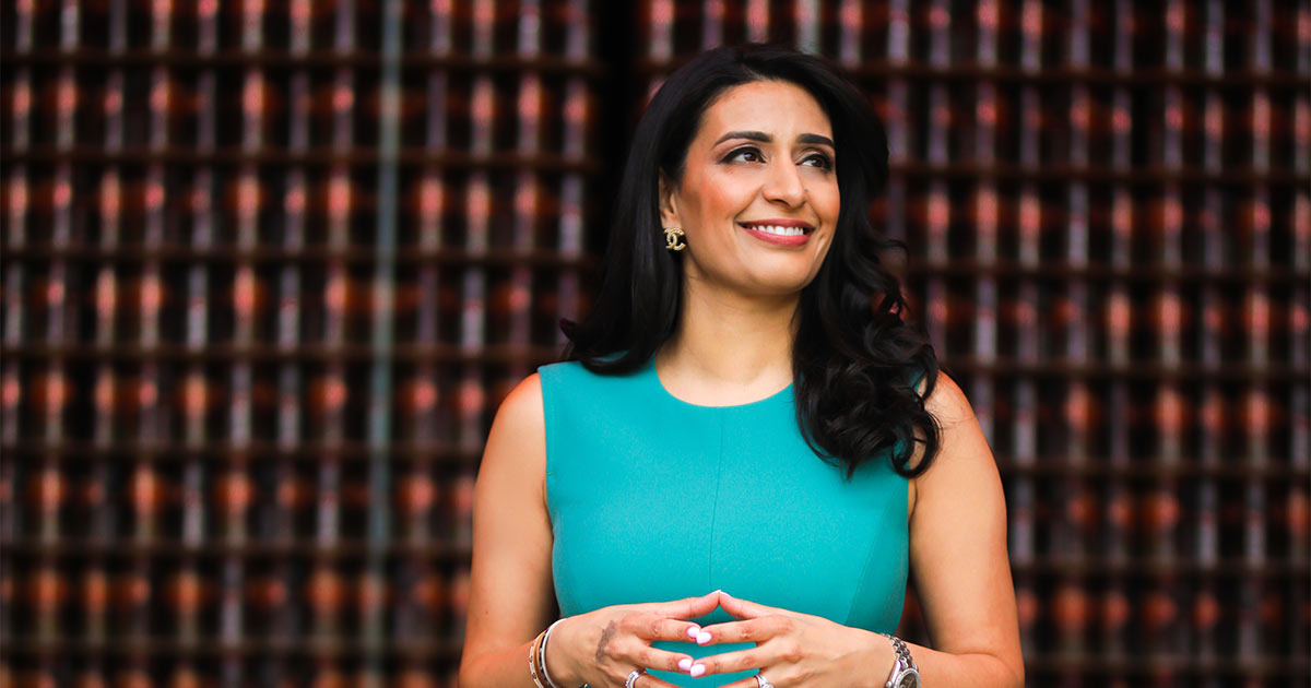 Manjit Minhas smiling and looking off-camera
