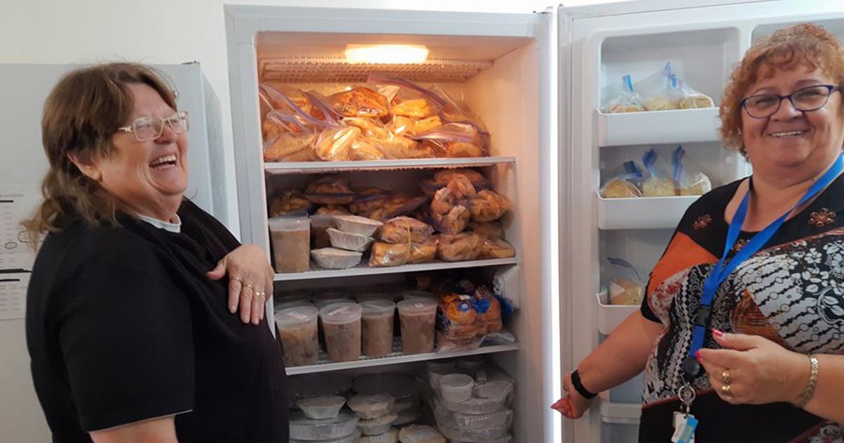 Legion volunteers showing off a fridge full of donated food
