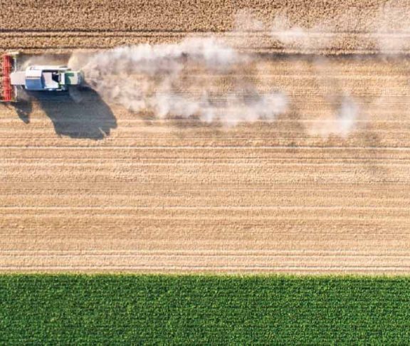 Aerial photo of farm machinery harvesting a large field