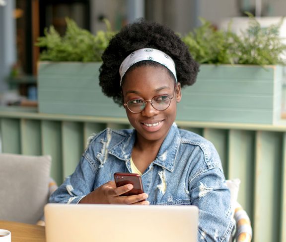 Young Black woman working at laptop and smiling