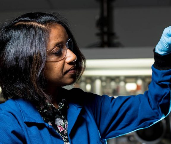 Female scientist inspecting vials of fluid