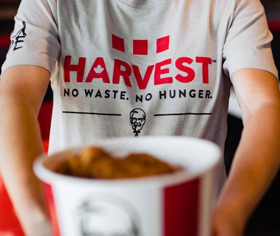 KFC Harvest volunteer holding a bucket of chicken