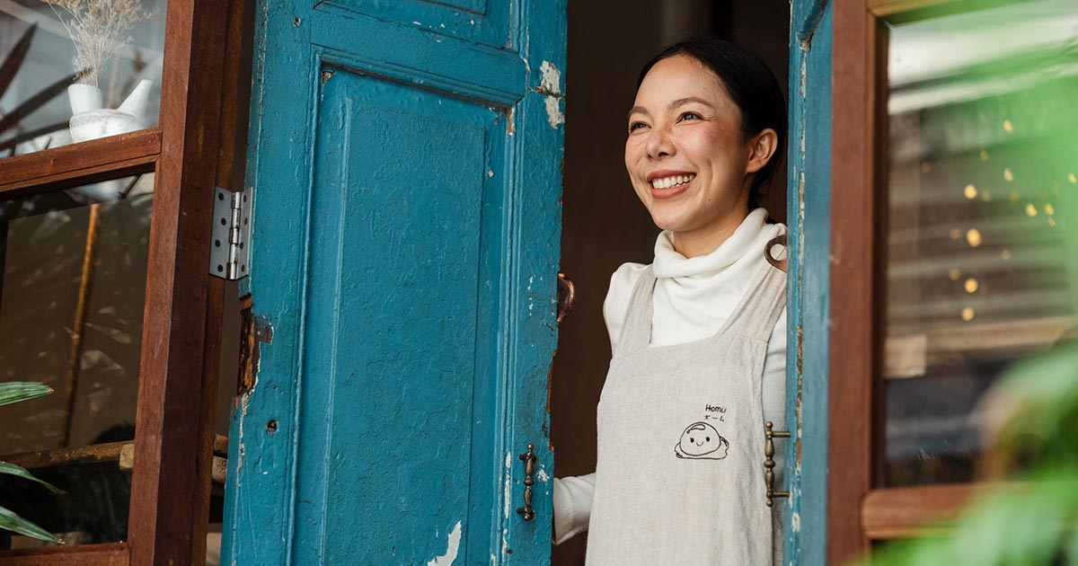 Smiling small business owner opening their doors