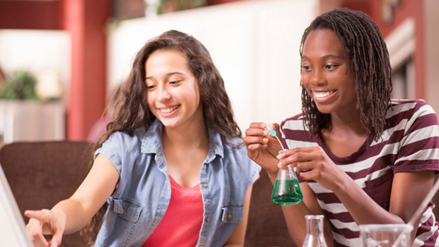 Two teen girls doing a science experiment at home