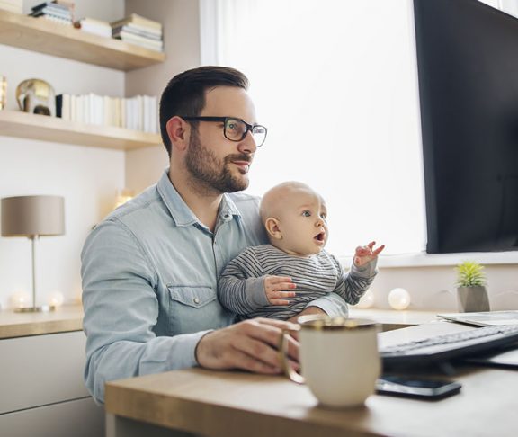 Man working in home office with his baby on his lap