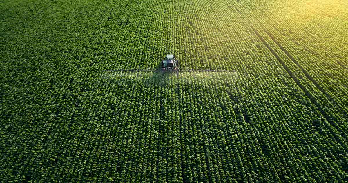 Aerial photo of a tractor tending to a large field of crops