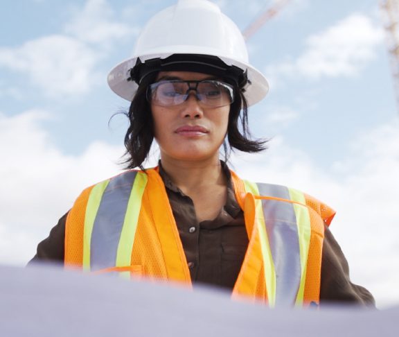 Female engineer looking at plans on a work site