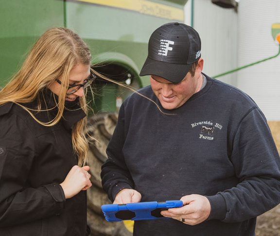 Two people using Climate FieldView technology on a tablet