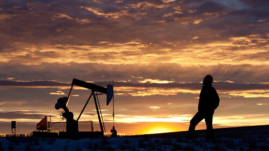Oil worker staring into sunset