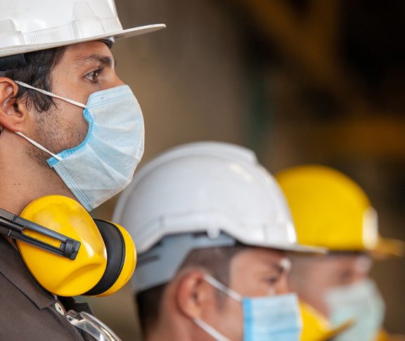 Workers wear protective face masks